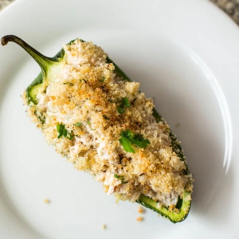 Golden-brown Cajun Crab Poppers spill creamy lump crab filling from halved jalapeños, flecked with herbs and a buttery panko crust.