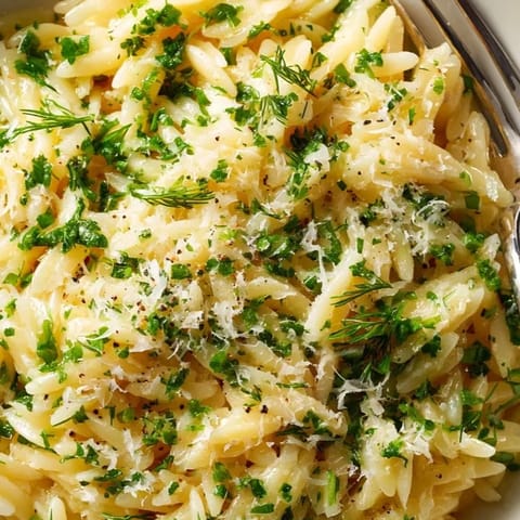 Close-up of Herb Butter Orzo: Al dente pasta glistening with melted butter and herbs.