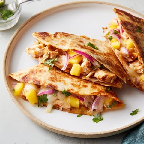 Close-up of cheesy mango chipotle chicken quesadillas, grilled golden and ready to serve.