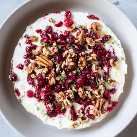 This festive lightened holiday cream cheese dip sparkles with cranberry and fresh herb garnish.