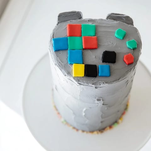 This pixel video game controller cake features a vibrant design, perfect for any video game fan's birthday.
