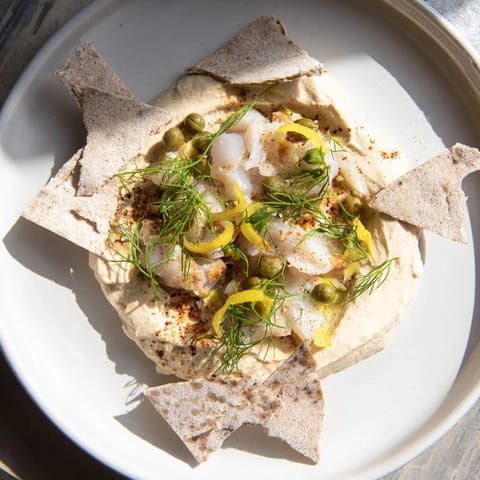 A beautiful, close-up shot of the Driftwood Beach appetizer, showcasing fresh dill and tasty fish.