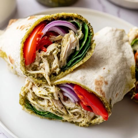 Delicious and colorful pesto chicken wrap, bursting with flavors and textures in every bite.