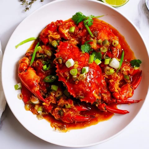 Steaming crab pieces simmered in the irresistible Singaporean Chili Crab sauce, perfect for dipping with fluffy buns.