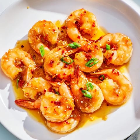 Plump Korean garlic butter shrimp, with green scallions, perfect for a flavorful appetizer.