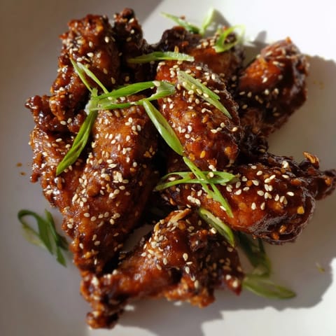 Tender Coca Cola Chicken Wings are glazed in a rich, caramelized sauce, paired with fluffy white rice for a complete meal.