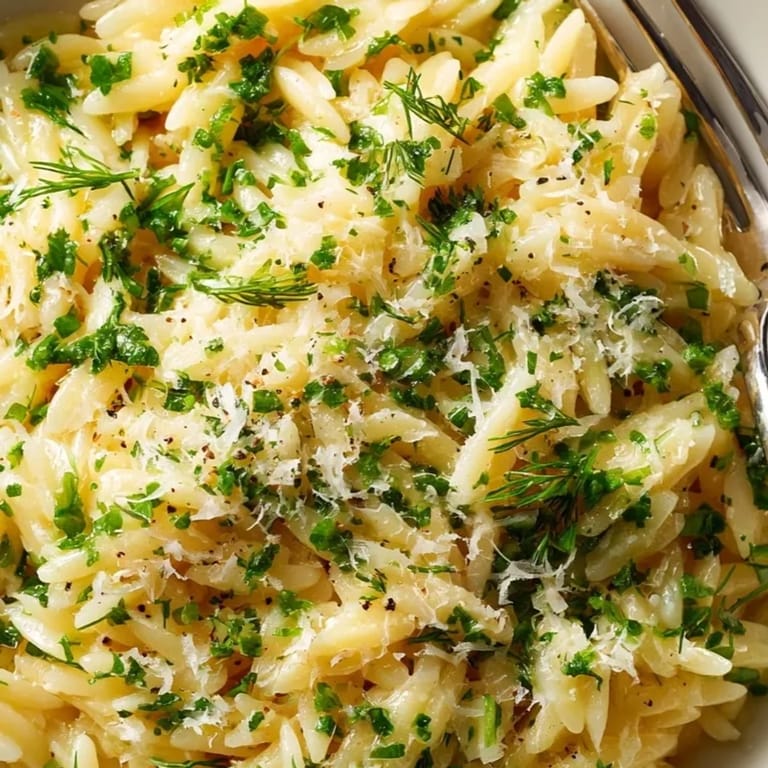 Close-up of Herb Butter Orzo: Al dente pasta glistening with melted butter and herbs.