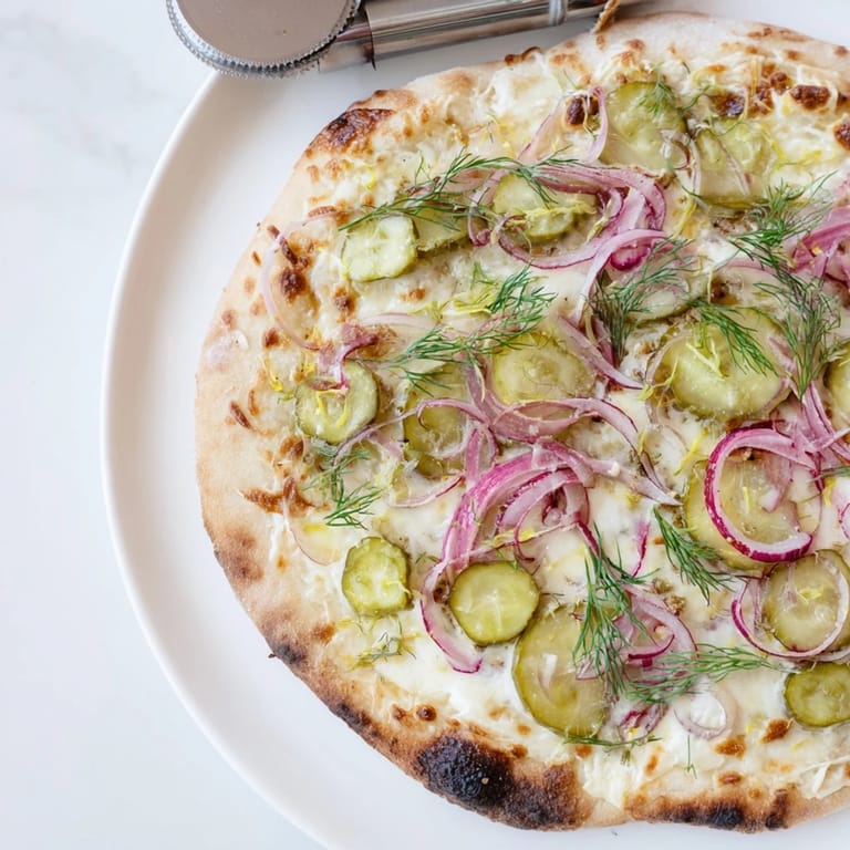 Delicious Pickle Pizza fresh from the oven, featuring melted mozzarella and fragrant dill.