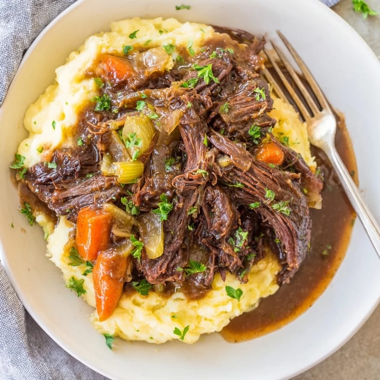 Aromatic Slow Cooker Pot Roast garnished with parsley, nestled on buttery mashed potatoes.