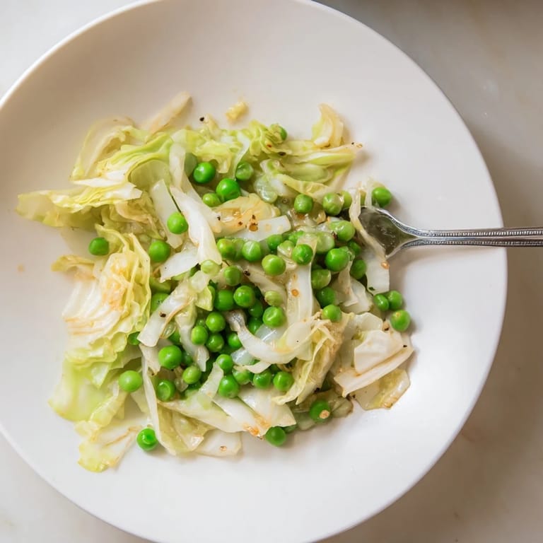 Vibrant plate of cabbage stir-fry, glistening from sesame oil, showcasing tender vegetables and savory sauce.