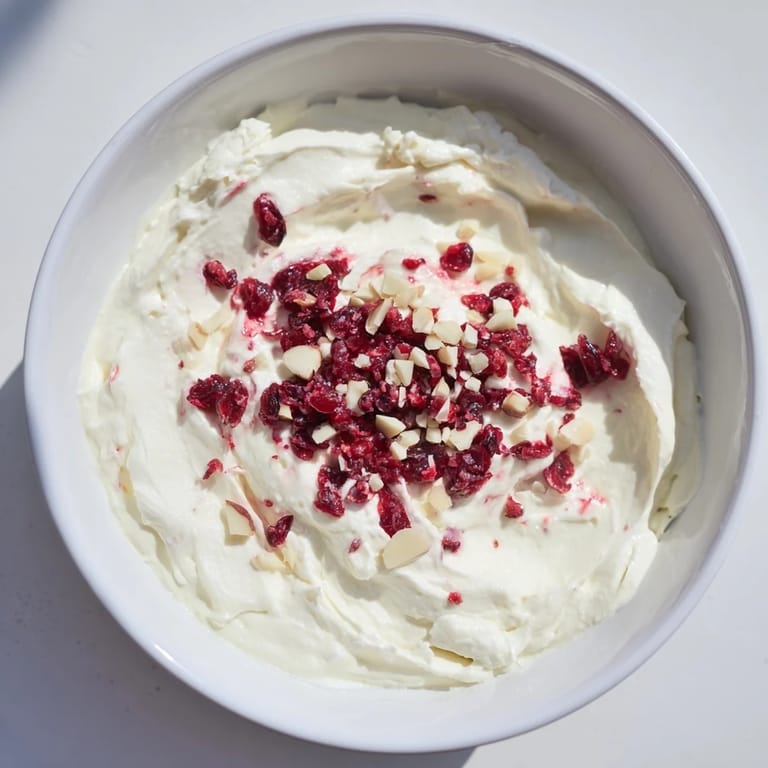 Enjoy the smooth texture of lightened holiday cream cheese dip, served with crackers, a perfect snack.