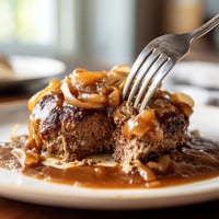 A fork is being used to eat a piece of meat.