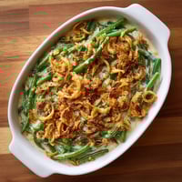 A white bowl with a green vegetable dish.