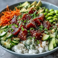 Colorful canned tuna poke bowl piled high with fresh vegetables and zesty dressing.
