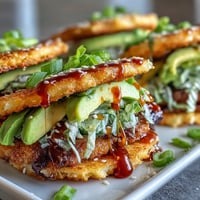 Crispy rice burger tacos with avocado and Sriracha drizzle.
